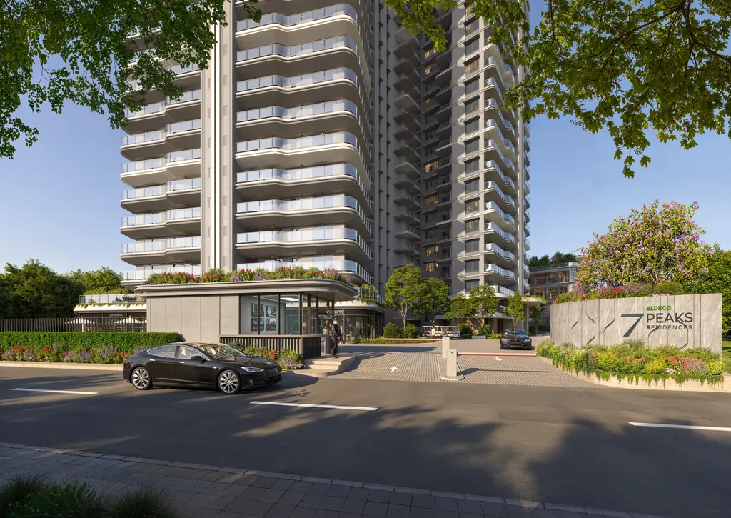 The gated entrance and signage wall at Eldeco 7 Peaks Residences, with a tower rising behind
